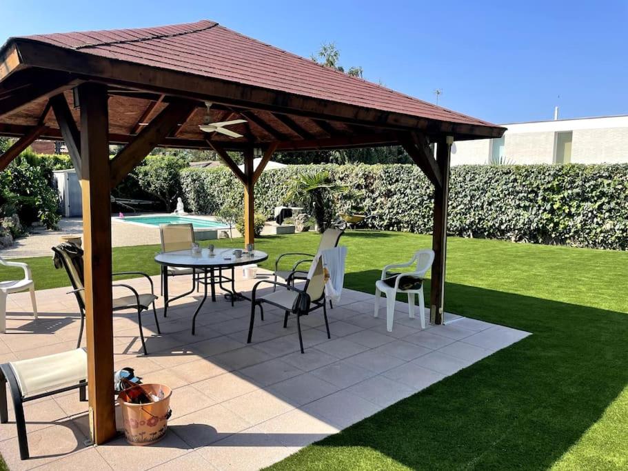 Odena的住宿－Villa Òdena，草坪上配有桌椅的木制凉亭