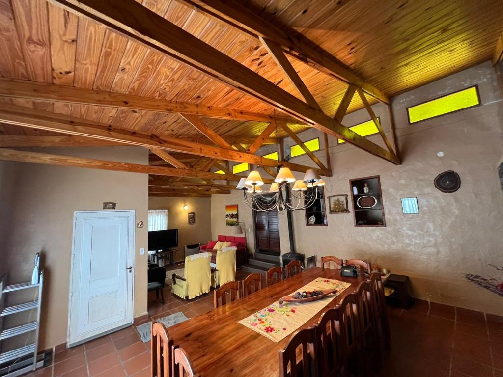 comedor y sala de estar con techo de madera en Casa de Montaña en La Angostura
