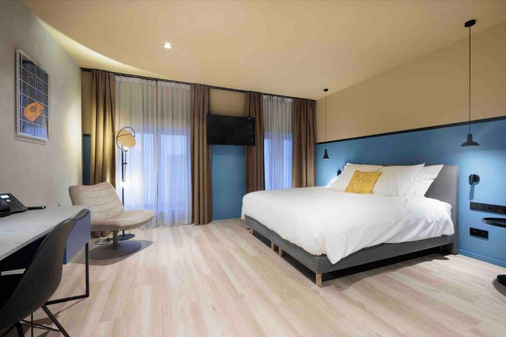 sypialnia z dużym białym łóżkiem i biurkiem w obiekcie M-Street art lodging - Self check-in w mieście Leuven