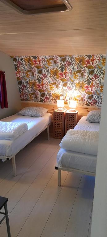 1 Schlafzimmer mit 2 Betten und einer Tapete in der Unterkunft Cabane randonneur au camping in Camurac