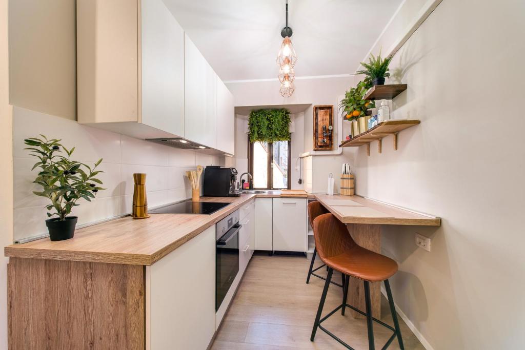a kitchen with white cabinets and a wooden counter top at City Center Studio Apartment for Humans & Pets - One in Rijeka
