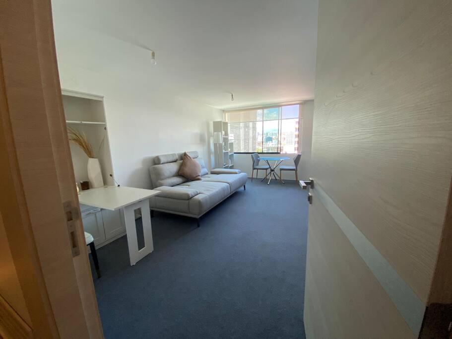a living room with a couch and a table at Hermosa Suite en edificio ecológico in Quito