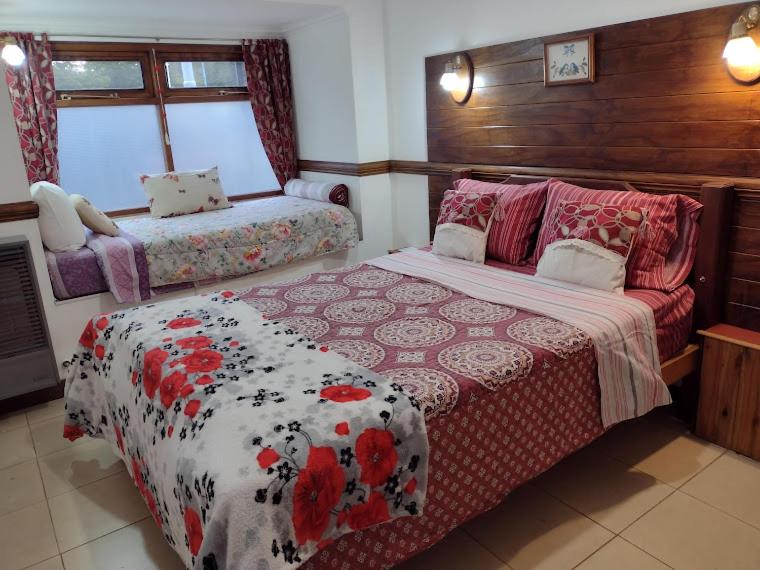 a bedroom with a bed and a bench in it at El Rincón del Andino - Planta Baja in Ushuaia