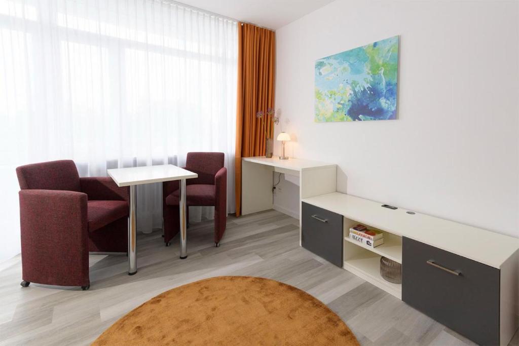 Zimmer mit einem Schreibtisch, 2 Stühlen und einem Tisch in der Unterkunft Huber Living Single 301 in Germering