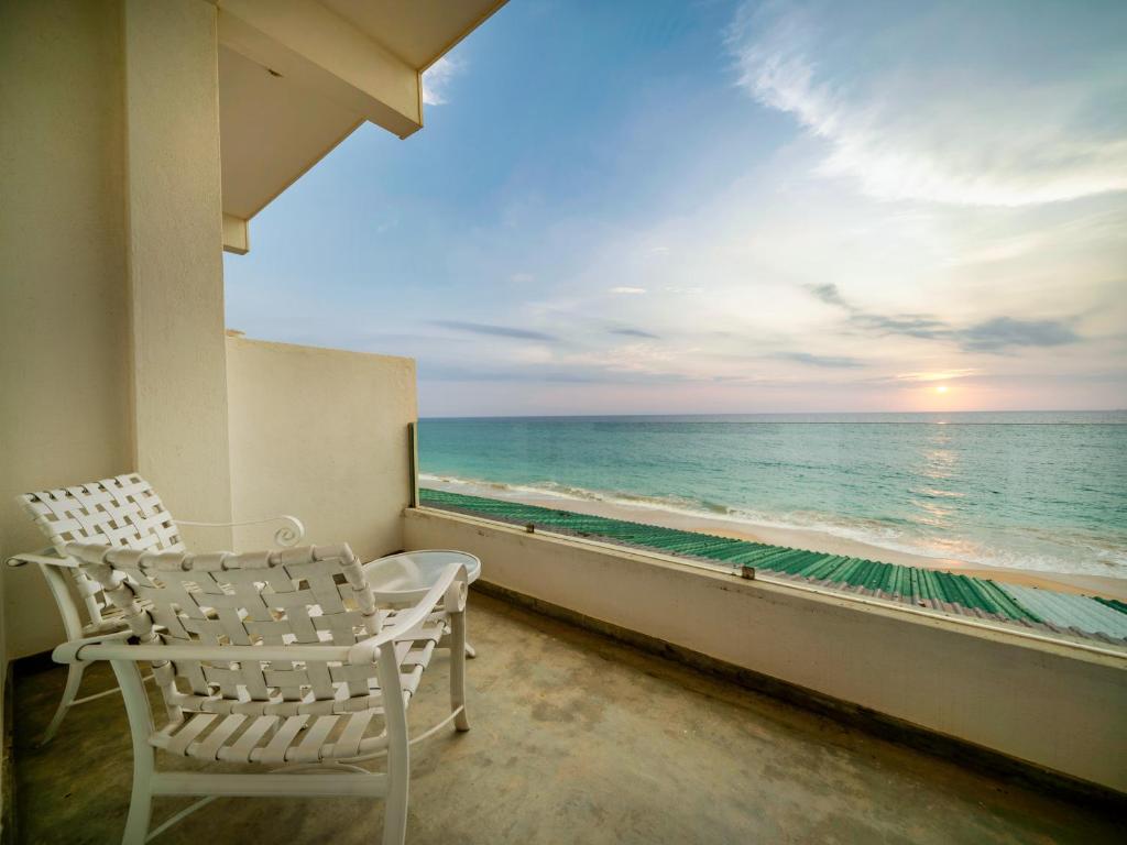 a white chair sitting on a balcony looking out at the ocean at Sea Breeze Ambalangoda in Ambalangoda