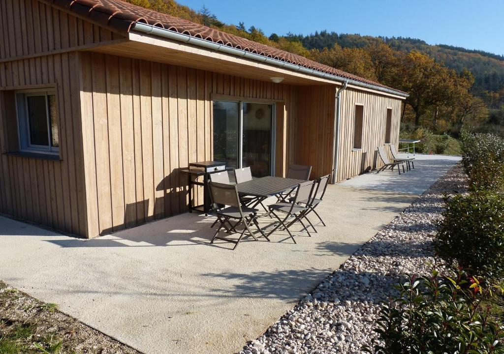 un patio avec une table et des chaises à côté d'un bâtiment dans l'établissement Le Coulabio Côté Soleil, Maison Lapopie 2, luxe et raffinement, à Tour-de-Faure