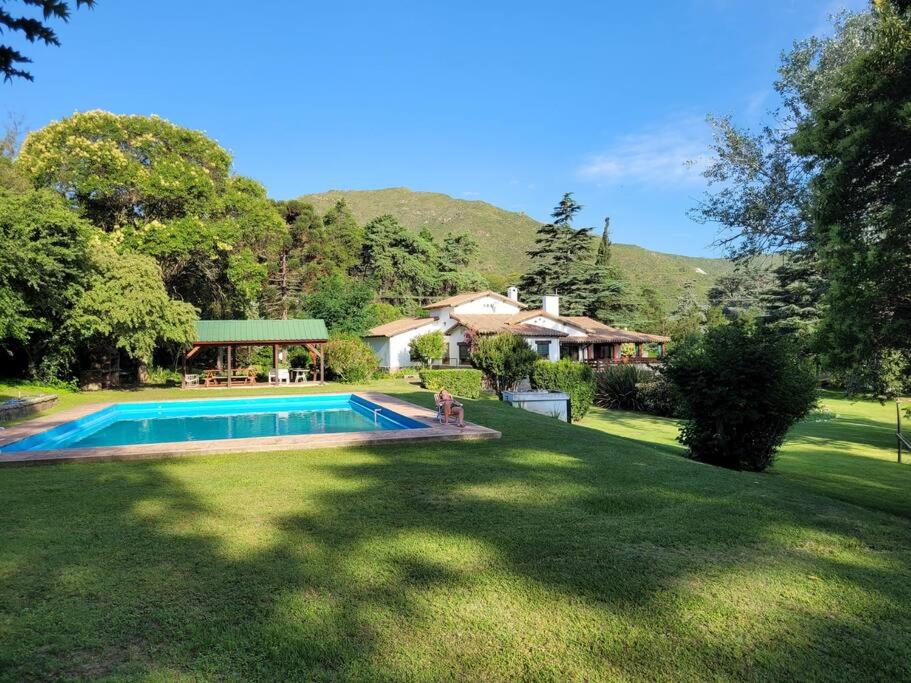 een huis met een zwembad in een tuin bij Amplia Casona de Estilo en La Falda in La Falda
