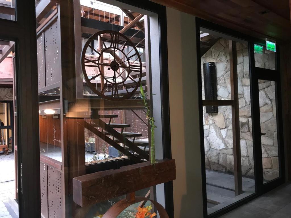 un reflejo de un reloj en la ventana de un edificio en AIKEN 19 en San Martín de los Andes