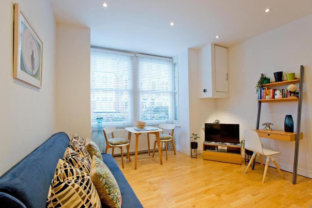 ロンドンにあるCosy Highbury Fields one bedroom apartmentの青いソファとテーブルのあるリビングルーム
