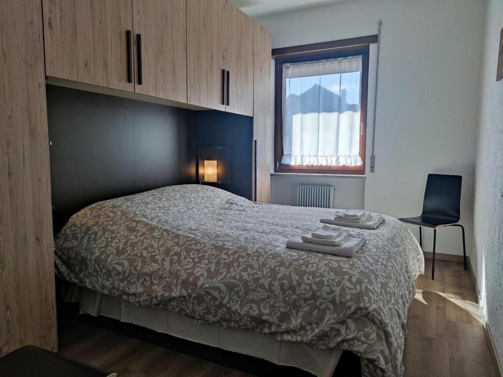 um quarto com uma cama, uma cadeira e uma janela em Residence Avila em Gallio