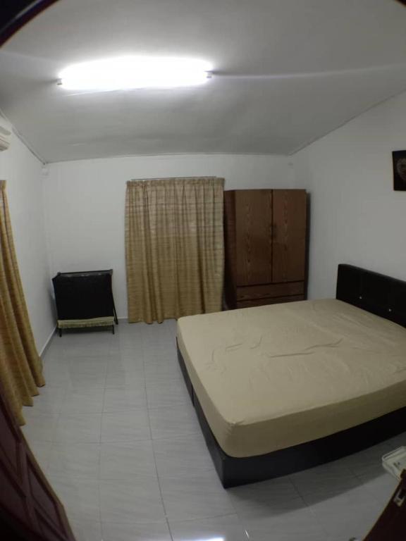 ein Schlafzimmer mit einem großen Bett und einem Fenster in der Unterkunft Sobey Laris Homestay UMK in Bachok
