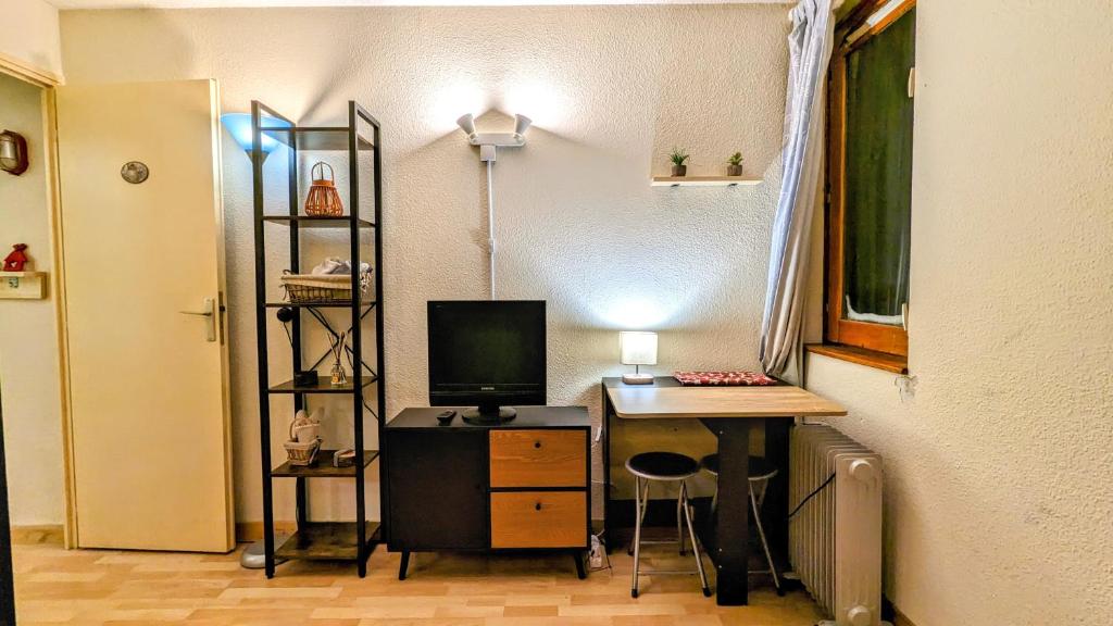 Cette chambre dispose d'un bureau avec un ordinateur et un moniteur. dans l'établissement Appartement La Mongie au pied des pistes, à Bagnères-de-Bigorre