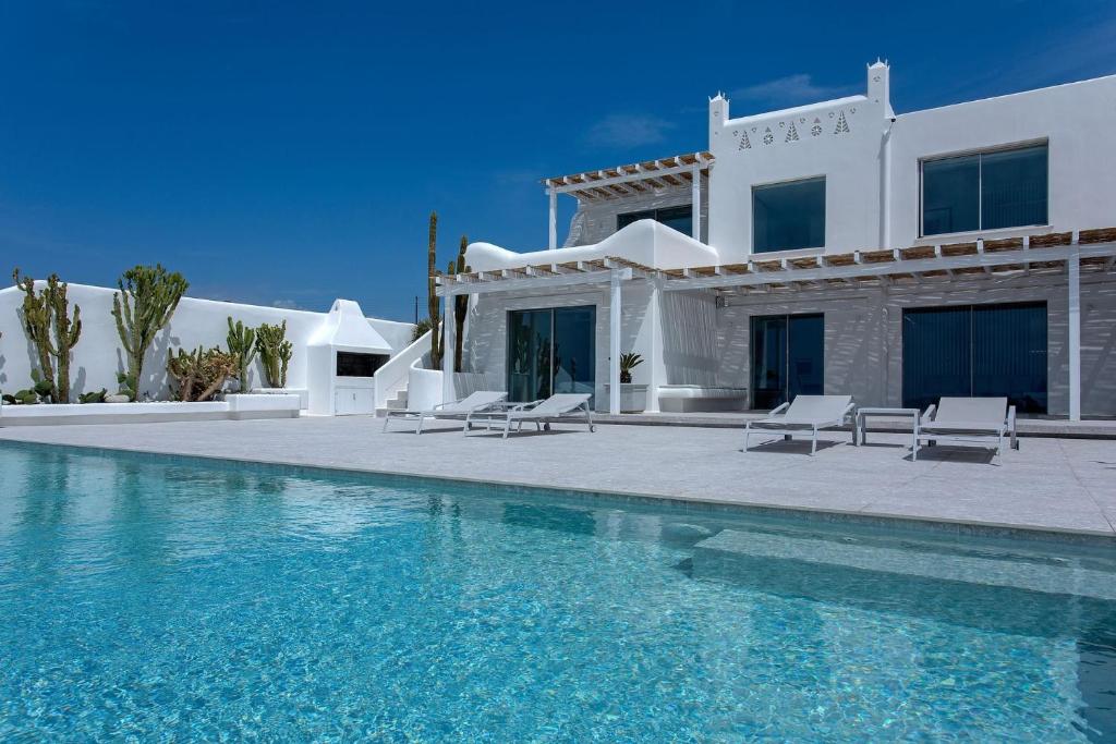 eine Villa mit einem Pool vor einem Haus in der Unterkunft Super Luxury Mykonos Villa - Villa Saorsa - 5 Bedroom - Infinity Pool - Panoramic Sea Sunset Views in Dexamenes