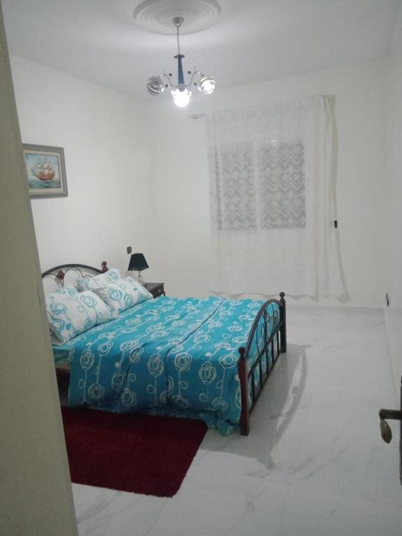 - une chambre avec un lit et une couette bleue dans l'établissement Bel app, à Agadir
