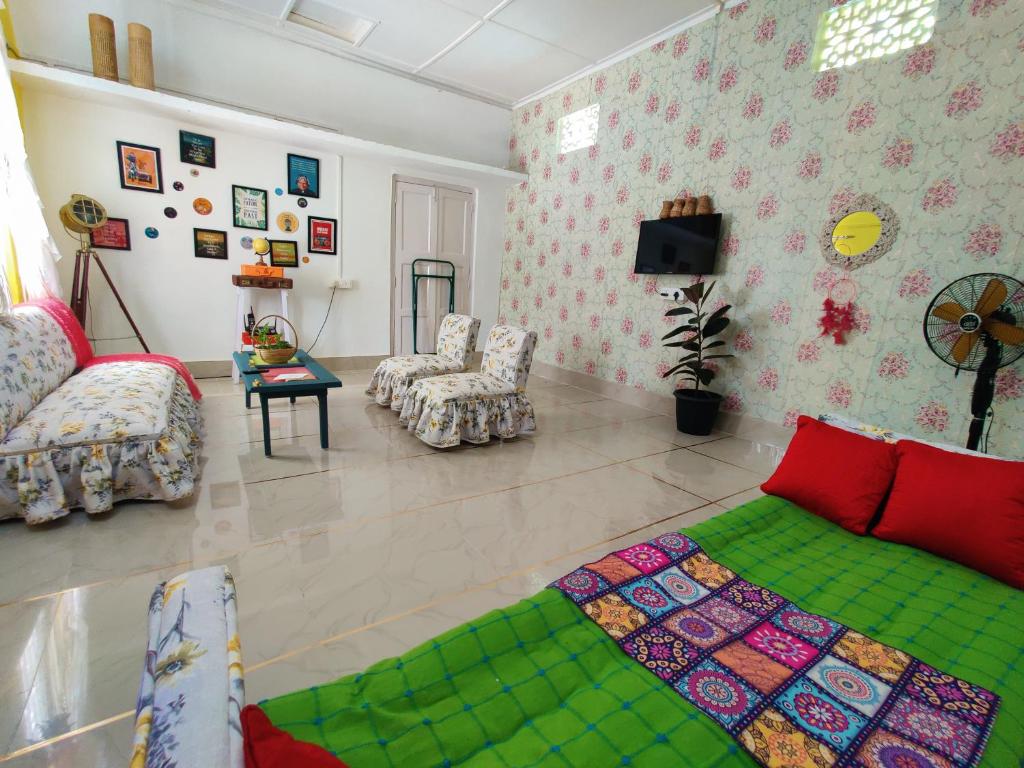 a living room with a bed and a couch at Gianna Homestay in Jorhāt