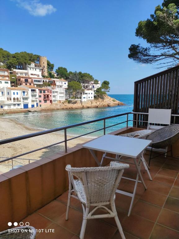 a table and chairs on a balcony overlooking the ocean at SATUNA BEACH CASA in Begur