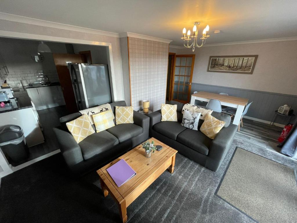 a living room with two couches and a coffee table at Self Catering Spacious 2 Bed Apartment with sea views in South Erradale