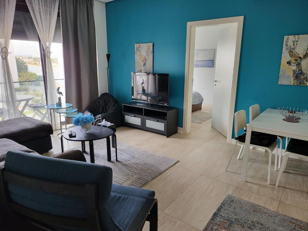 uma sala de estar com um sofá e uma televisão em Blue Diamond Ayla - Restricted to Family stays em Aqaba