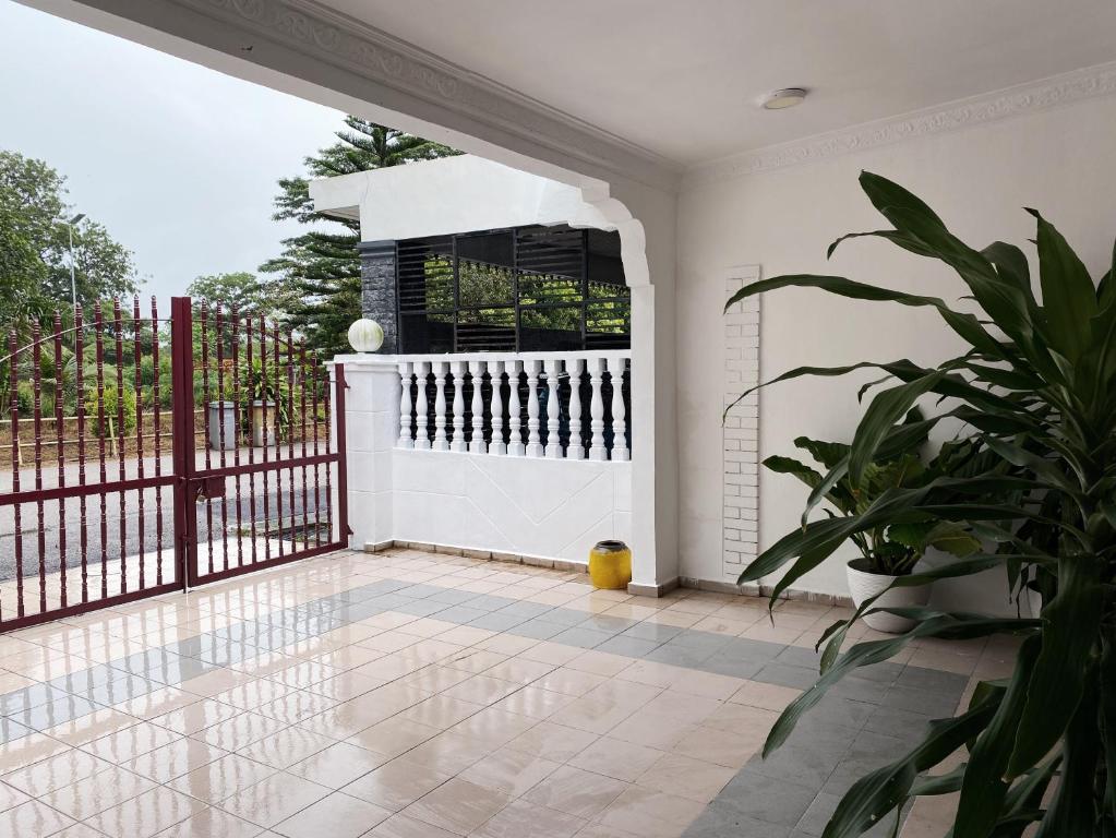 a white room with a gate and a potted plant at Hinggap Cendana in Masai
