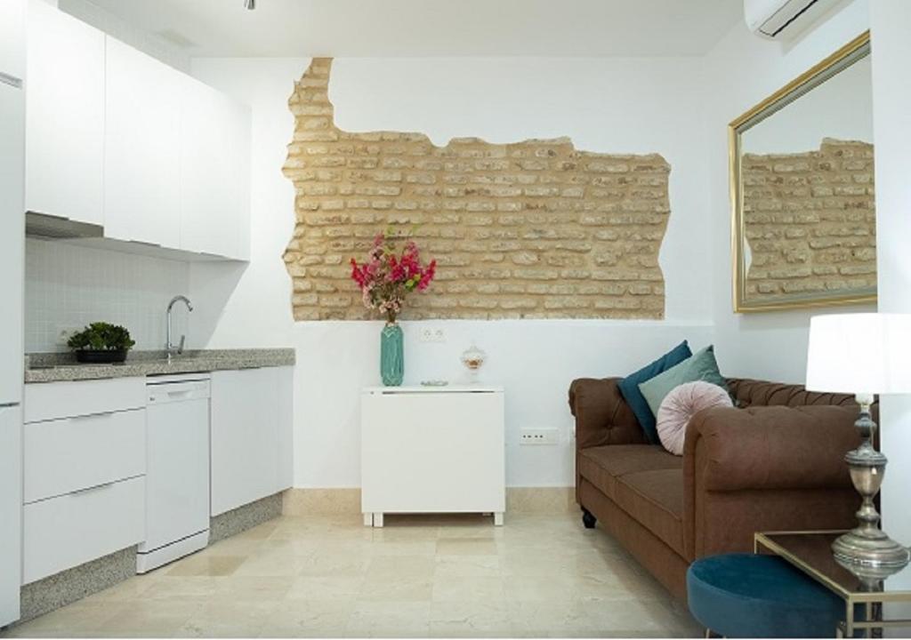 ein Wohnzimmer mit einem Sofa und einer Küche in der Unterkunft La Judería del Buen Viaje in Sevilla