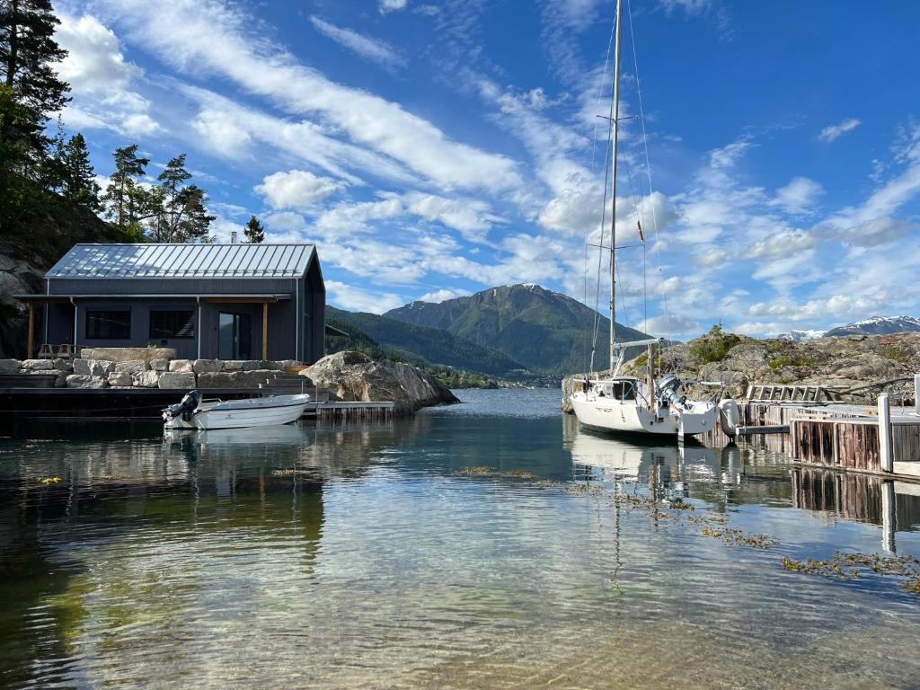 una casa su un molo con barche in acqua di Stunning Holiday Rental by the Waterfront a Sogndal
