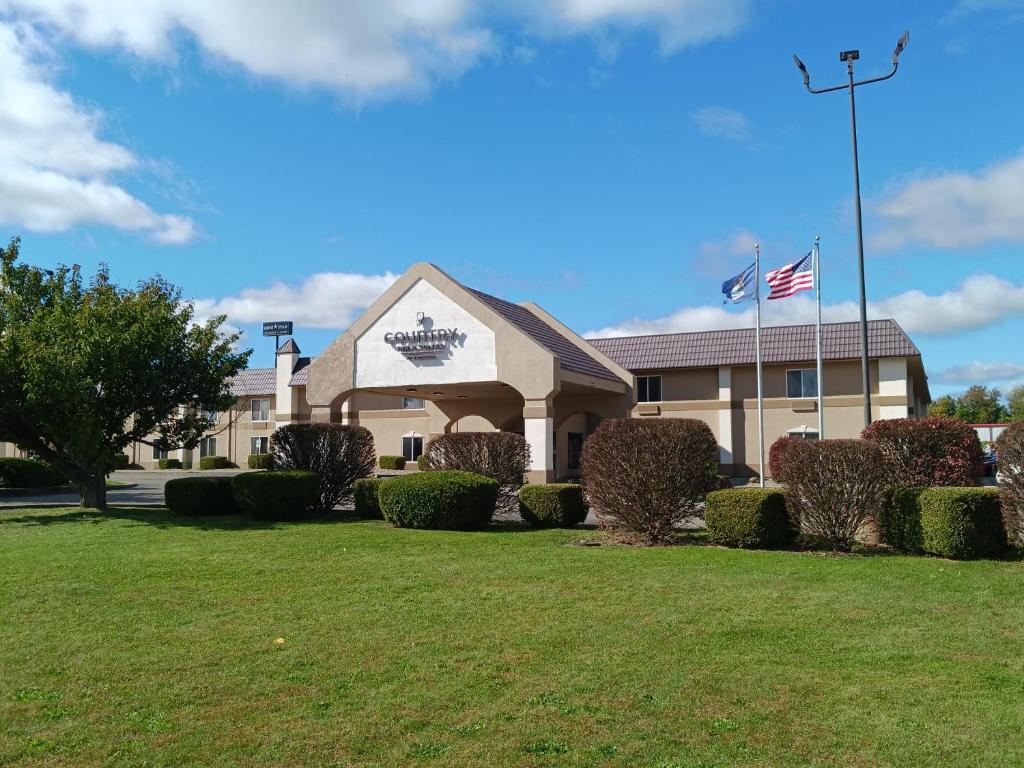 un edificio con césped delante en Country Inn & Suites by Radisson, Battle Creek, MI, en Battle Creek