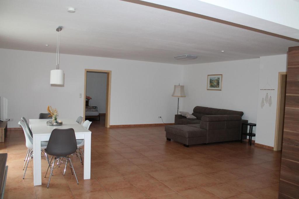 ein Wohnzimmer mit einem weißen Tisch und einem Sofa in der Unterkunft Ferienwohnung in Ruppichteroth Winterscheid in Ruppichteroth