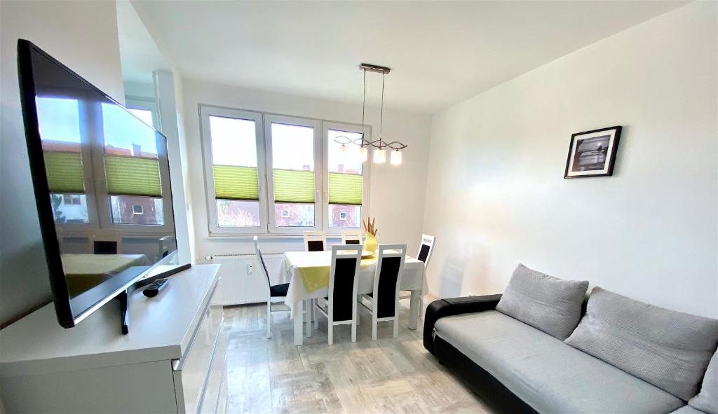 a living room with a couch and a dining room at Apartament Słoneczny Ustka in Ustka