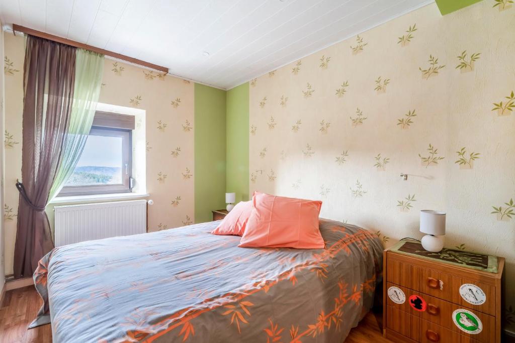 a bedroom with a bed with an orange pillow and a window at Maison de 3 chambres avec jardin clos et wifi a Dabo in Dabo