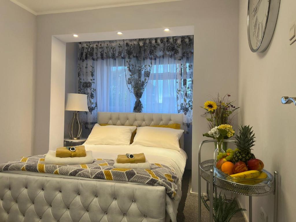 a bedroom with a bed with a window and fruit on a table at Apartment Luxe FREE WIFI, FREE PARKING, FREE NETFLIX in Friern Barnet