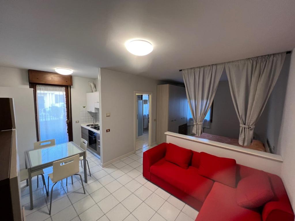 un soggiorno con divano rosso e tavolo di Appartamento Civico 23 a Brescia