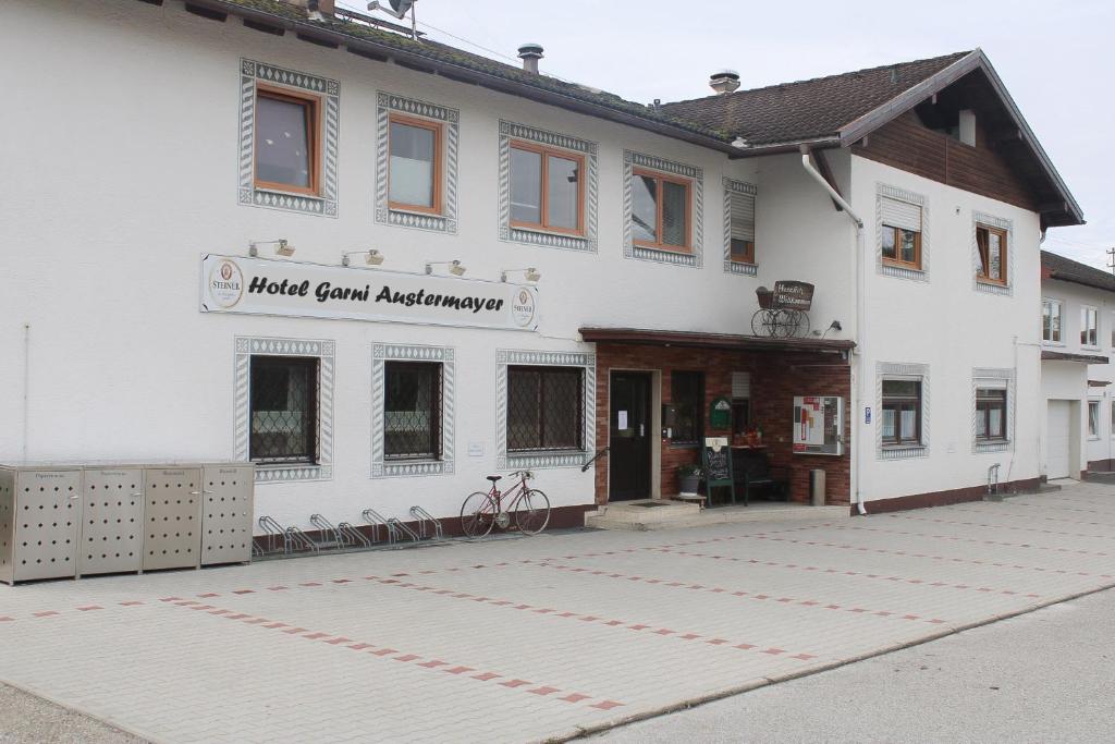 un edificio blanco con una señal que dice logros de cabra negra en Hotel Garni Austermayer, en Traunreut