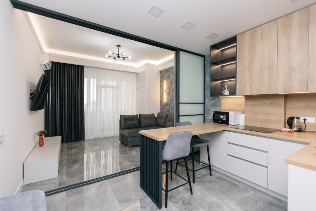 a kitchen and living room with a table and chairs at Luxury Apartment in Chişinău