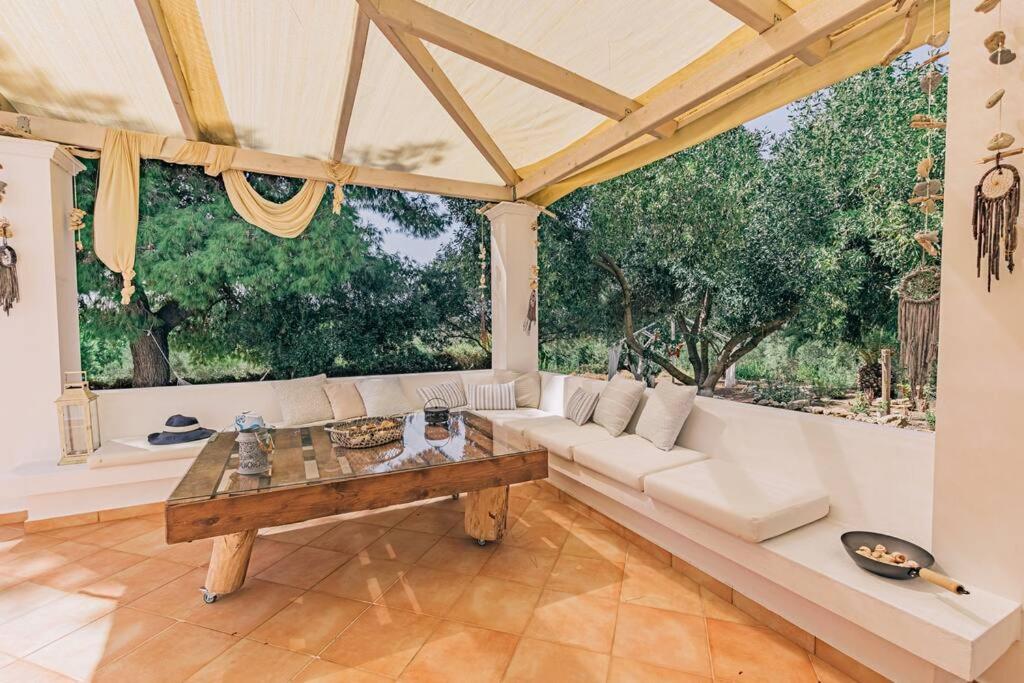 a living room with a white couch and a table at Villa Dionisia, Relaxation with Jacuzzi Retreat in Svoronata