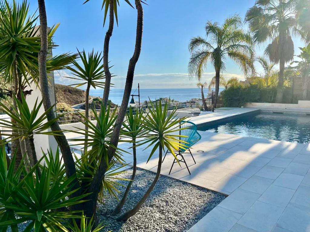 a swimming pool with palm trees and the ocean at Villa de luxe vue mer et piscine privée casa de Palma à Torrox Costa in Torrox Costa