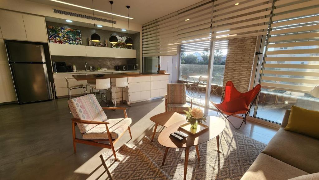 Il comprend un salon avec une table et des chaises ainsi qu'une cuisine. dans l'établissement White Night by Holyguest, à Tel Aviv