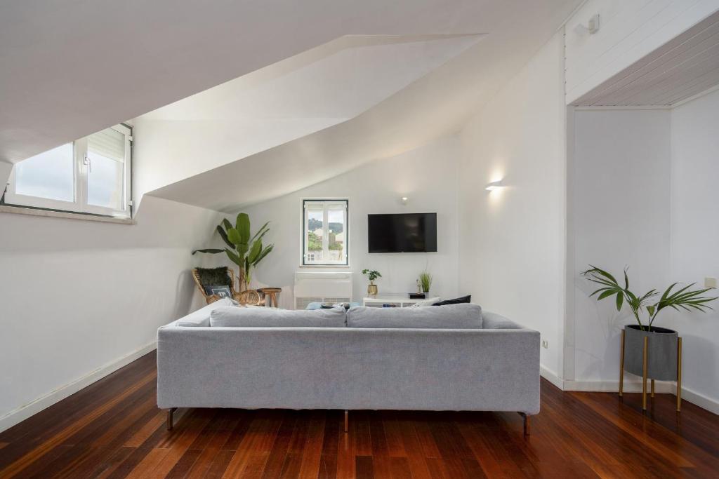 a living room with a gray couch in a white room at Setubal Downtown N97, By Home Match in Setúbal