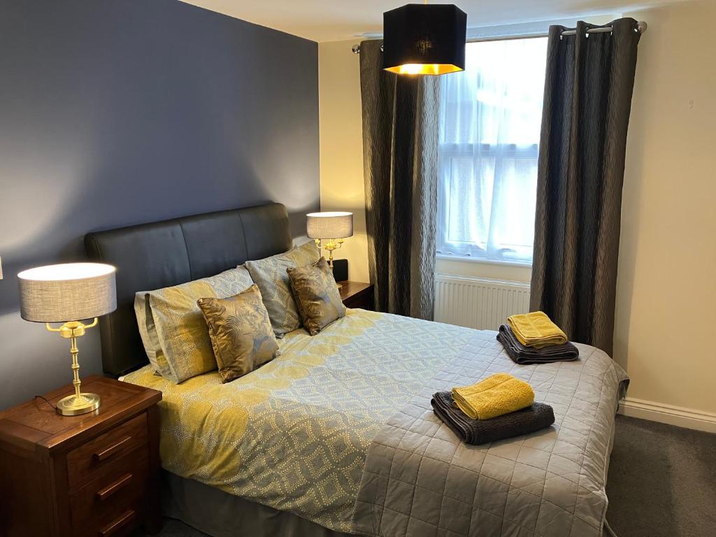 a bedroom with a bed with two pillows and a window at THE OCEAN SUITE - 2 minute walk to the lovely beach front promernade of llandudno in Llandudno