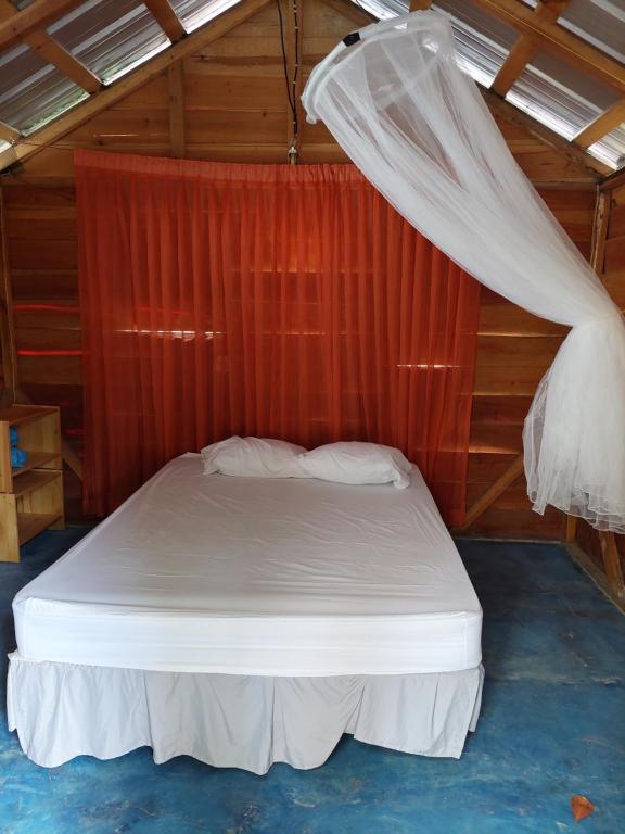 a bed in a room with a mosquito net at Cabana Playa Cambiaso in San Felipe de Puerto Plata