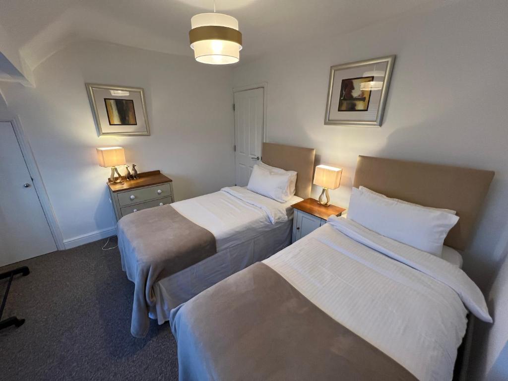 a hotel room with two beds and two lamps at First floor flat with parking in Wheatley