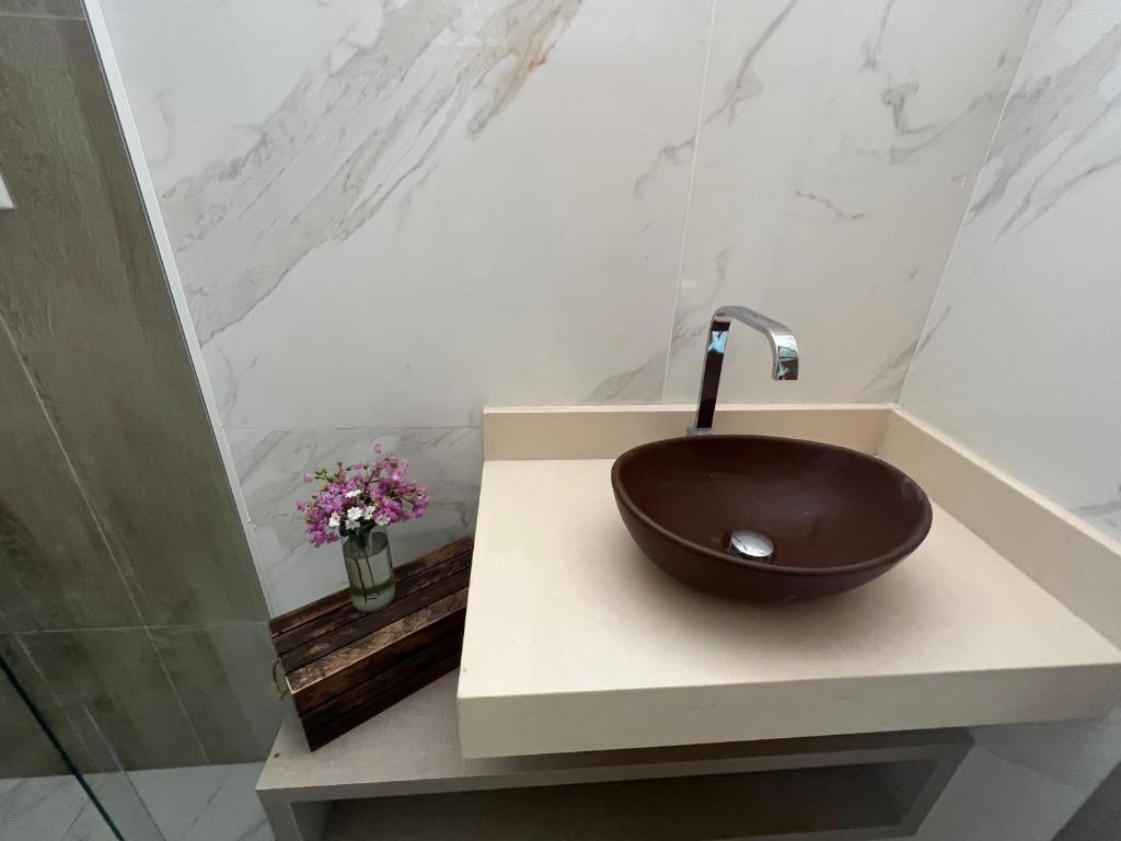 La salle de bains est pourvue d'un lavabo brun sur un comptoir. dans l'établissement CasaCactus em Tamoios na quadra da praia junto a Barra de São João, à Cabo Frio