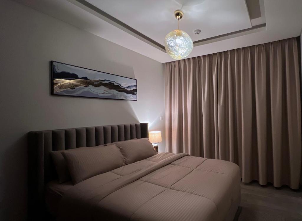 a bedroom with a bed and a chandelier at Luxury apartment in Muscat Hills in Muscat