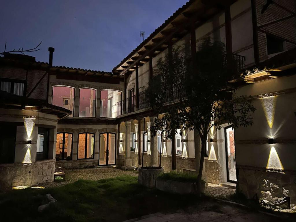 un viejo edificio con un árbol en el patio en Casa de los Mendoza - Casa Solariega en el casco histórico, en Alcalá de Henares