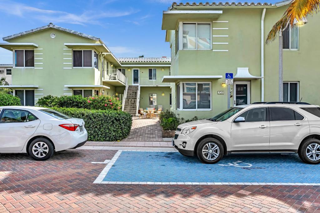 two cars parked in a parking lot in front of a house at Sea Angel in Hollywood Beach