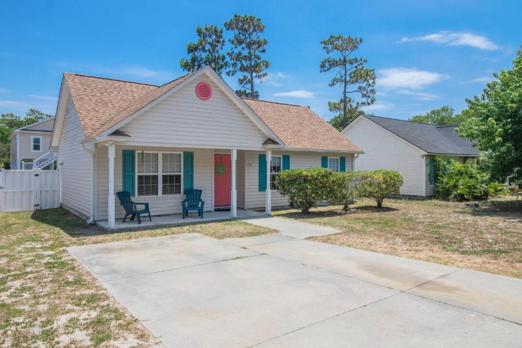 a white house with a red door at The Hairy Crab in Oak Island