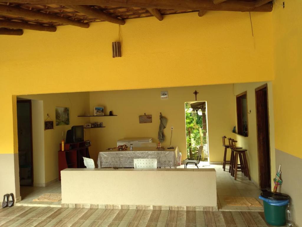 un salon avec un mur jaune dans l'établissement Maravilhosa praia do Sargi - BA, à Serra Grande