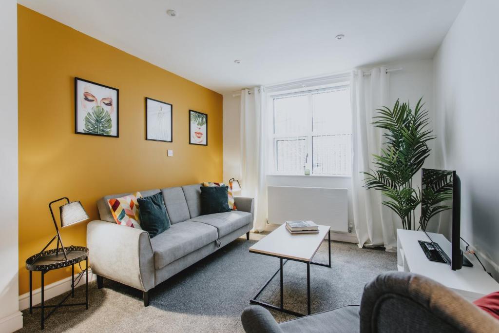 uma sala de estar com um sofá e uma mesa em Spacious Apartment Near City Centre - Free Parking, Wi-Fi with King Size Bed em Nottingham