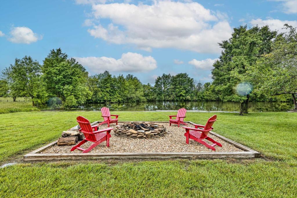 two red chairs and a fire pit in a field at Waterfront Nevada Escape with Private Pond and Dock! in Nevada
