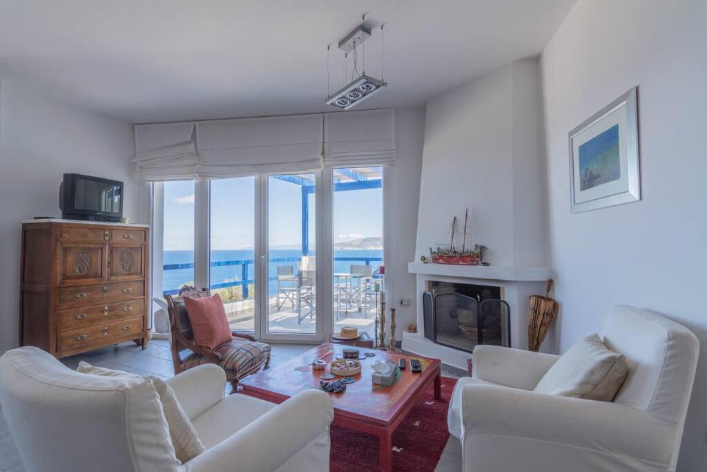 d'un salon avec un mobilier blanc et une vue sur l'océan. dans l'établissement Overlooking Porto 9, à Vromopoúsi