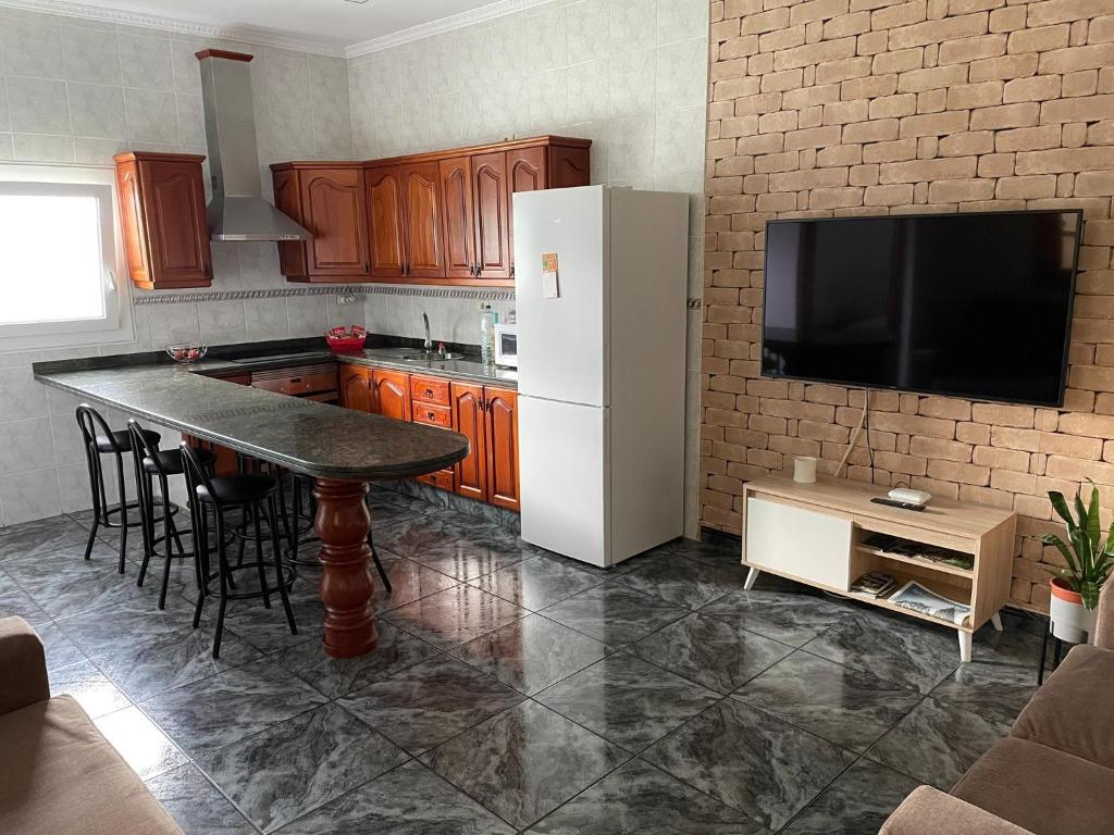uma cozinha com uma mesa e um frigorífico branco em Pico Lomito House em Moya